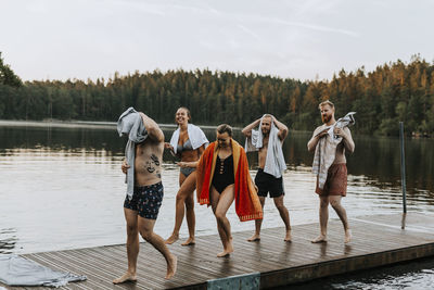 Smiling friends walking on jetty