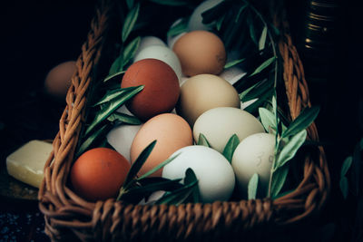Close-up of eggs and herbs in basket on table