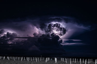Scenic view of sea against storm clouds at night
