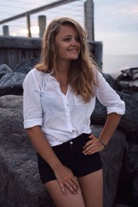 Young woman leaning on rock