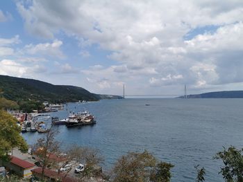 Sailboats moored on sea against sky