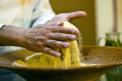 Close-up of hands scattering wheat