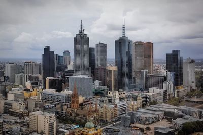 Modern cityscape against cloudy sky