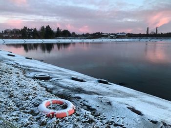 Scenic view of lake in winter at sunset