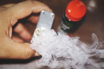 Close-up of hand holding cigarette