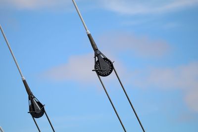 Low angle view of pulley against blue sky