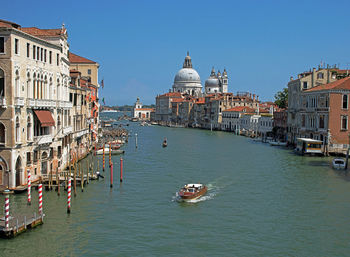 Boats in canal amidst buildings in city