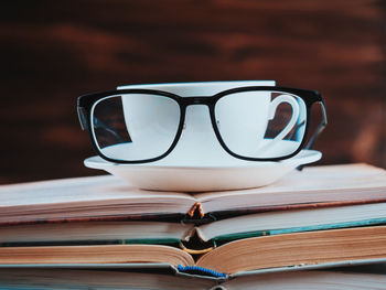 Close-up of coffee in cup on stacked books at table
