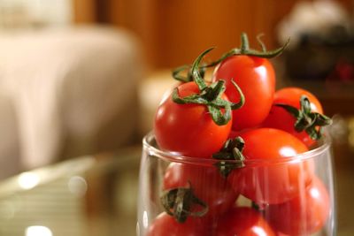 Close-up of tomatoes in glass container on table