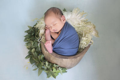 High angle view of girl sleeping in basket