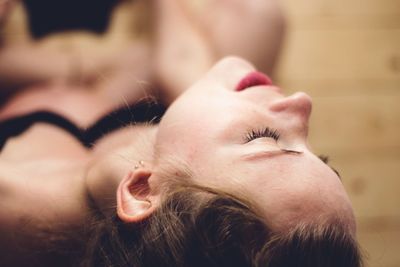 High angle view of young woman with eyes closed sitting on floor