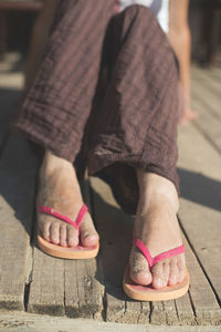 Low section of person with pink shoes on footpath