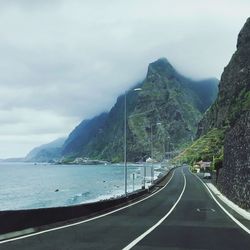 Road by sea against mountain