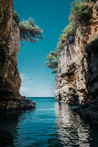 Rock formation in sea against sky