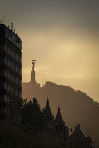 Buildings in city at sunset