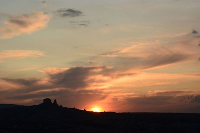 Scenic view of silhouette rocks against sky during sunset