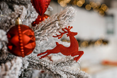 Closeup of balls and deer on christmas tree. bokeh garlands in the background. christmas concept.