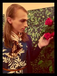 Beautiful young woman standing by flowering plants