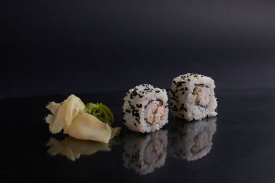 Close-up of sushi against black background