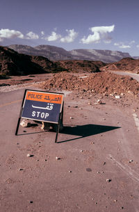 Information sign on desert against sky