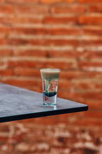 Close-up of drink on table against wall