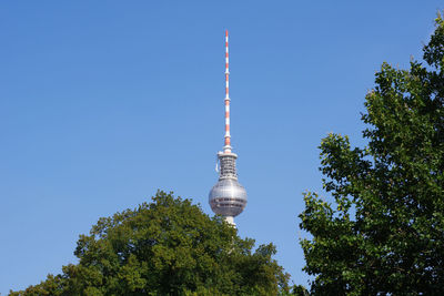 Low angle view of communications tower against clear blue sky