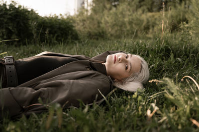 Portrait of beautiful young woman lying on grass