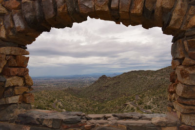 Scenic view of rock formation against cloudy sky