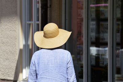 Rear view of woman standing against door