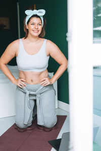 Young woman plus size body positive in  sport wear practice yoga with knee protection online at home