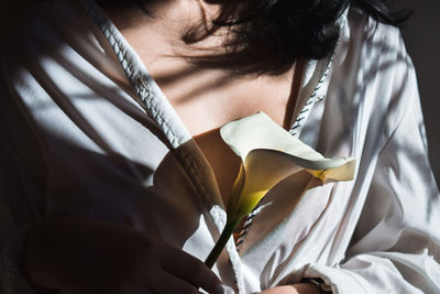 Midsection of woman holding flower