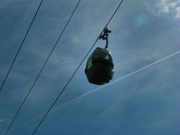 Low angle view of overhead cable car against sky