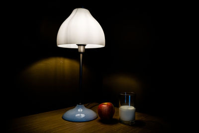 Lamp on table against black background