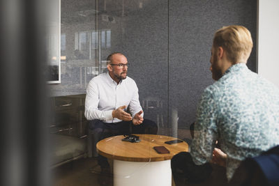 Businessman discussing with male colleagues in office