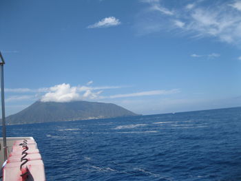 Low section of person on sea against blue sky