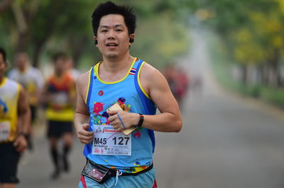 Smiling young man running outdoors