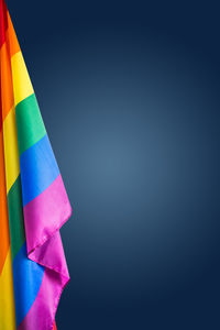 Close-up of multi colored flags against blue background