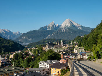 High angle view of townscape and mountains against clear blue sky