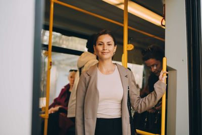 Portrait of smiling young woman in tram during city exploration