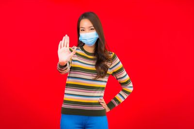 Woman standing against red background