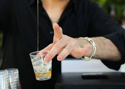 Midsection of man preparing drink