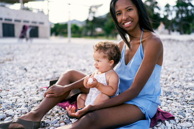 Mother and daughter sitting at beach