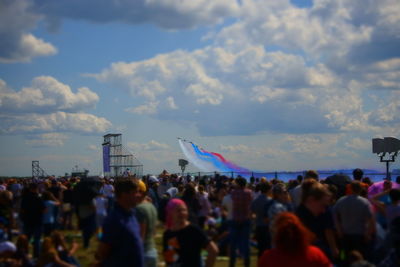 Crowd at music concert against sky