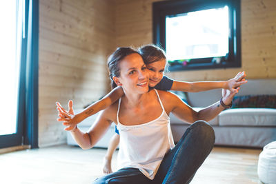 Side view of young woman exercising at home