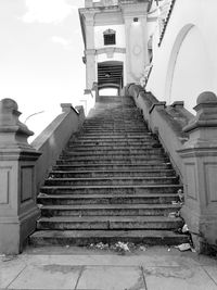 Low angle view of steps amidst buildings against sky