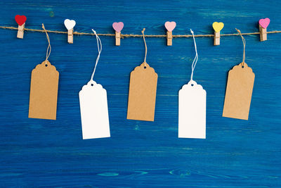 Close-up of clothespins hanging on clothesline against blue sea
