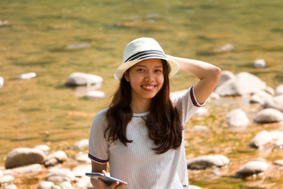 Portrait of smiling young woman standing outdoors