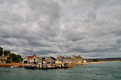 Scenic view of sea by buildings against sky