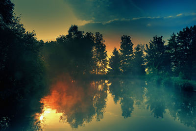 Scenic view of lake against sky at sunset