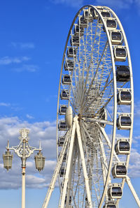 Low angle view of ferris wheel against blue sky